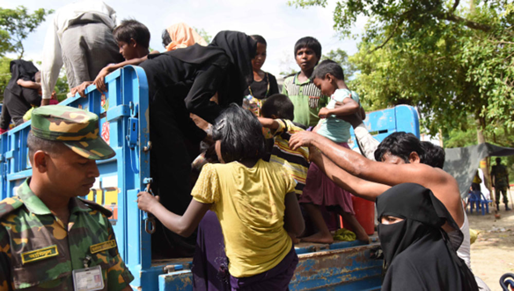 A Bangladeshi soldier watches as Rohingya refugees board a truck taking them to refugee camps in Cox’s Bazar district, after they crossed over from Myanmar, Sept. 25, 2017. Photo: Abdur Rahman/BenarNews 