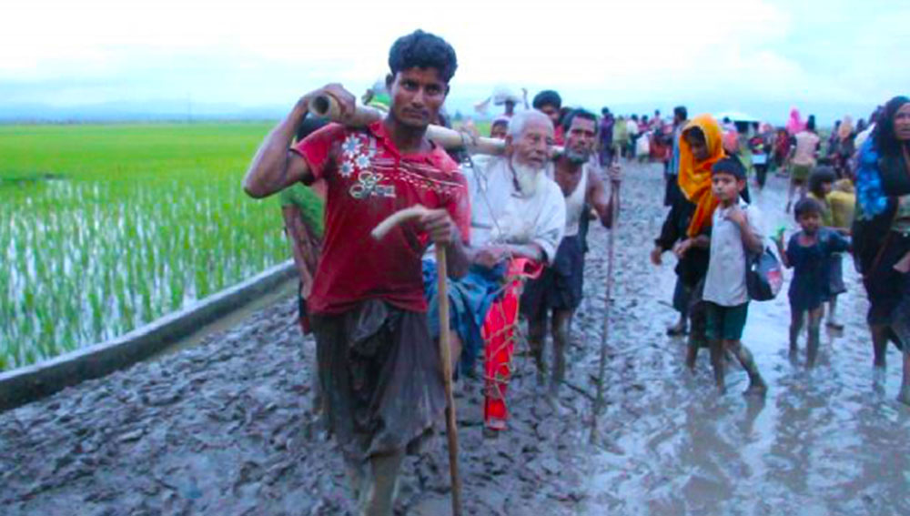 Rohingya refugees carry an old man in Teknaf, in southeastern Bangladesh, Sept. 4, 2017. Photo: Abdur Rahman/BenarNews 