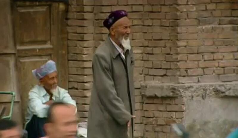 چىقىلىۋاتقان قەشقەر كونا شەھەر ۋە مەسچىتلەرگە ئېچىنىپ قاراۋاتقان بوۋاي.