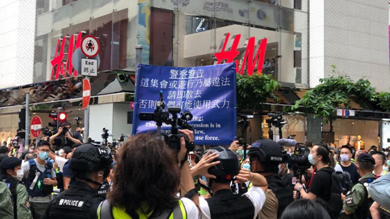警方高舉藍旗指現場屬非法集會。（文海欣 攝）