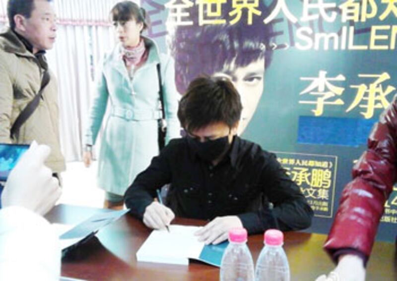 1月12日，李承鵬在成都簽書會被國保禁言，他戴著口罩簽書。（照片來自維權人士）