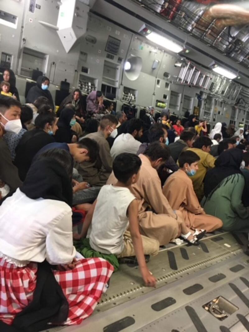 ئافغانىستاندىن كۆچمەنلەرنى ئىتالىيەگە توشۇۋاتقان ئايروپىلاندا ئولتۇرغان كىشىلەر. 2021-يىلى 25-ئاۋغۇست.