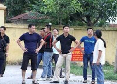 Công an, an ninh đứng trước trại Lộc Hà ngăn cản những người đến đón người bị bắt. File photo.