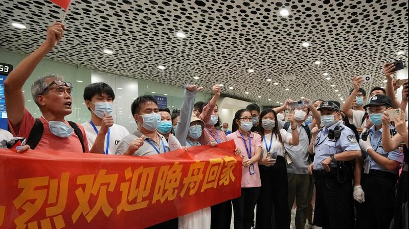 2021 年 9 月 25 日,深圳市的深圳宝安国际机场,支持者手持横幅欢迎孟晚舟回家。路透社图片