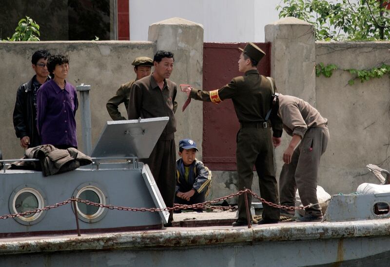 2009년 5월, 신의주 인근 압록강에서 북한 군인이 배에 탄 사람들과 대화하고 있다.
