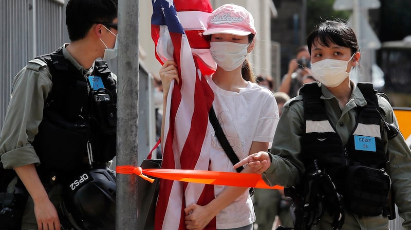 2020年7月4日,香港防暴警察拦阻一名举着美国国旗的香港抗议民众。(美联社)