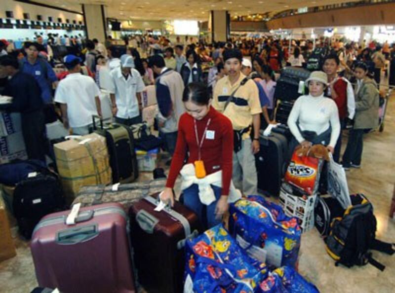 Người Việt tị nạn chờ đợi check-in tại sân bay quốc tế Manila để đến Hoa Kỳ ngày 26 tháng 9 năm 2005.