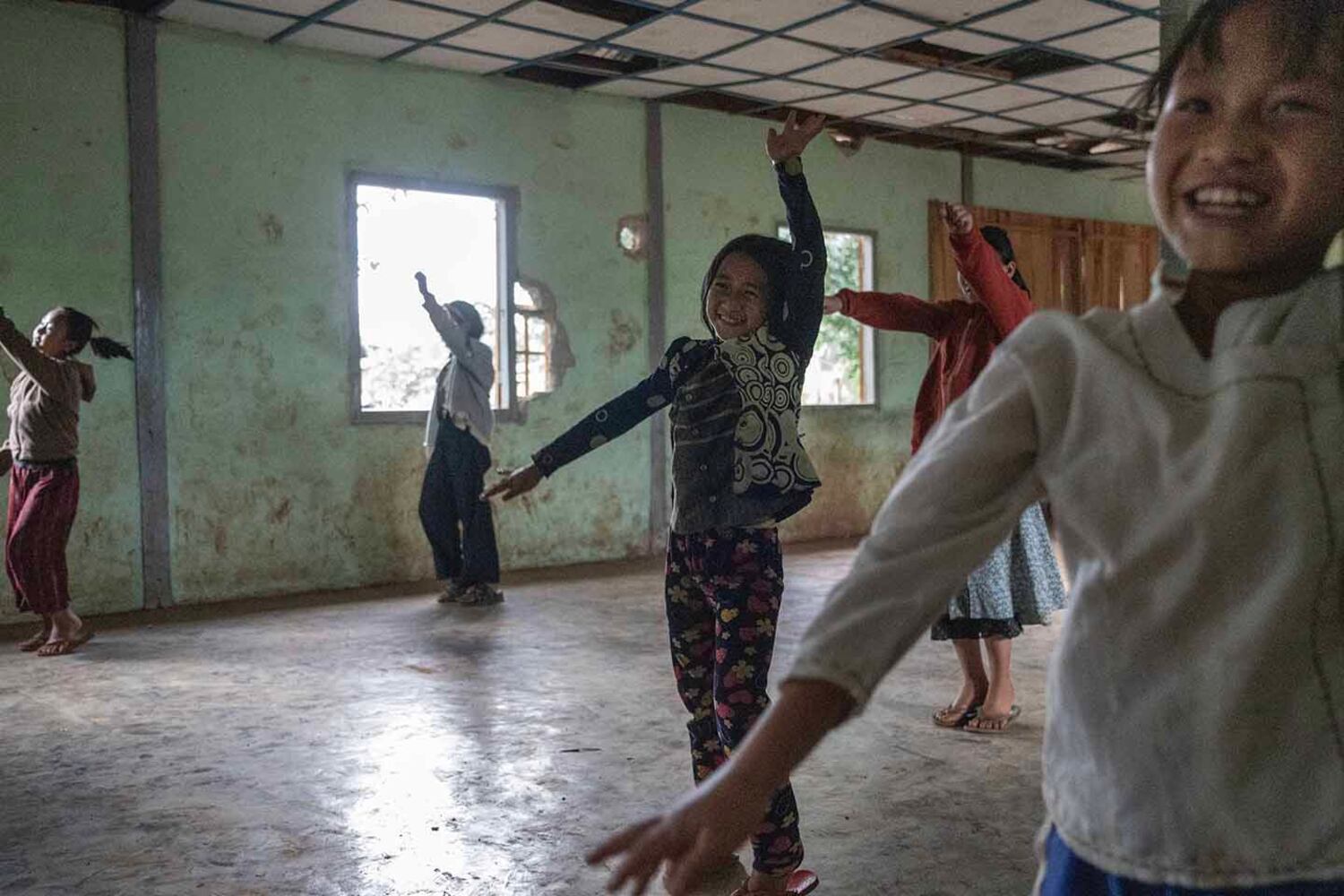 Schoolchildren dance close to a building that was damaged by a March 2024 junta airstrike in Lwe Yin town, southern Shan state Myanmar, Oct. 28, 2024.