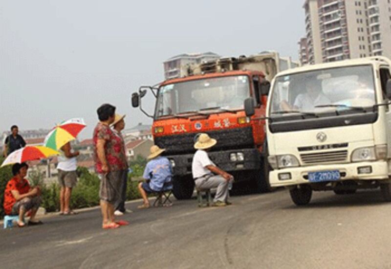 武漢市盤龍城數十名居民本周二（7月17日）將通往垃圾發電廠的河堤主幹道堵塞，阻止途經的垃圾車駛進。（居民提供）