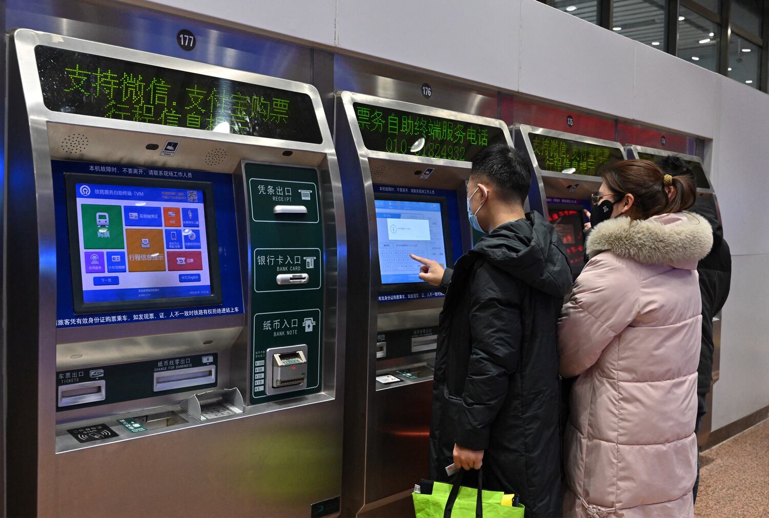 People use a ticket machine at a train station in Beijing, Jan. 20, 2025.