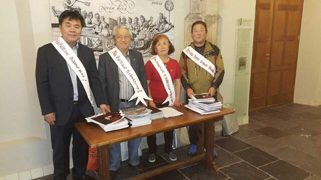 네덜란드 라이덴대학 아시아센터에서 진행된 '유럽내 북한해외근로자 인권유린실태 보고서 발표' 행사장에서 인권관련 소책자들을 나눠주는 탈북민들.