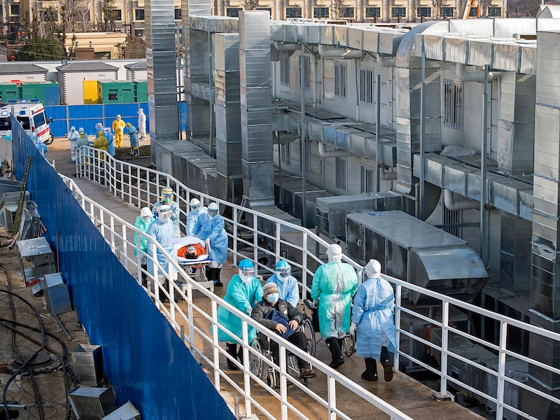 Medical staff transport COVID-19 patients at the Huoshenshan makeshift hospital in Wuhan, China, Feb. 4, 2020.