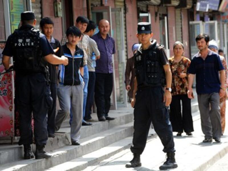 Chinese riot police keep watch on Uyghur residents near a mosque in Urumqi following ethnic violence between Uyghurs and Han Chinese, July 10, 2009.