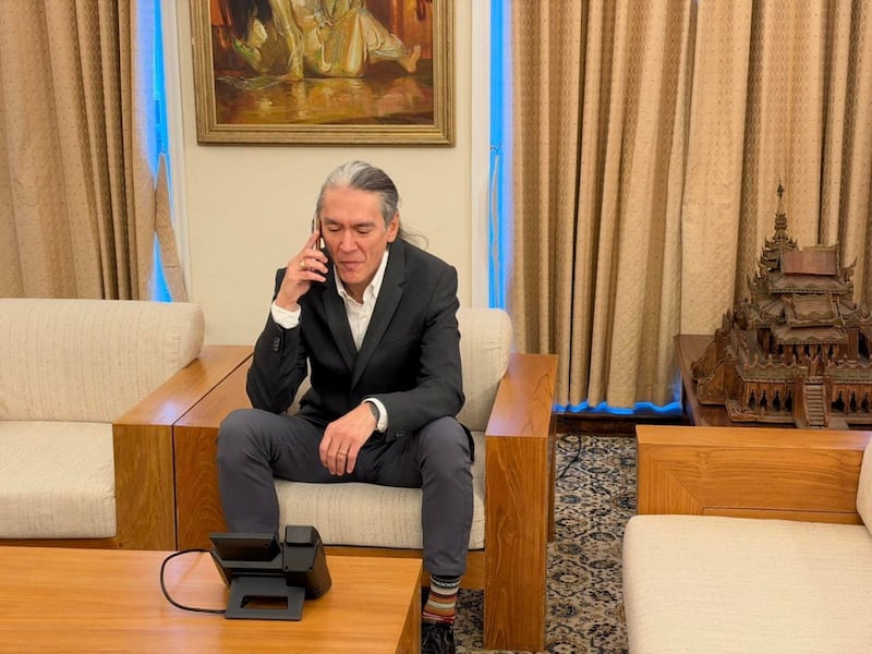 Aung San Suu Kyi's son, Kim Aris, at the Myanmar Embassy in London talks on the phone with his mother, in Naypyitaw, Myanmar, Oct. 22, 2026.