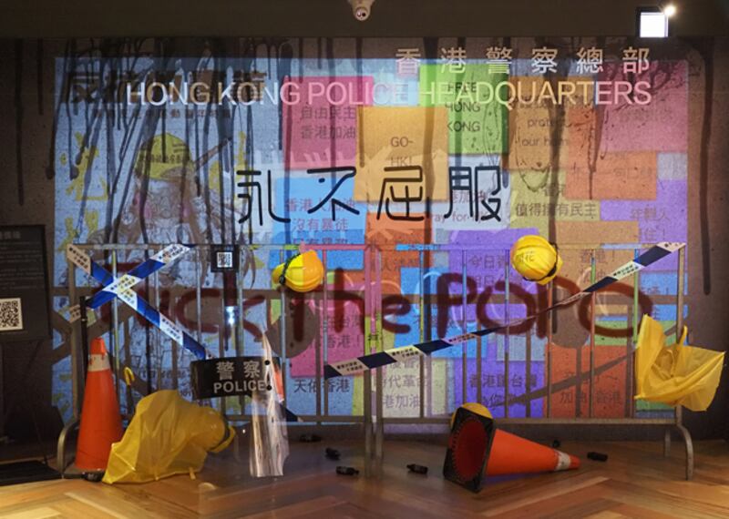 2020年6月24日,展覽其中一個主題,以數位連儂牆疊影在香港警察總部,表現出港警和中國的連結。(鍾廣政 攝)