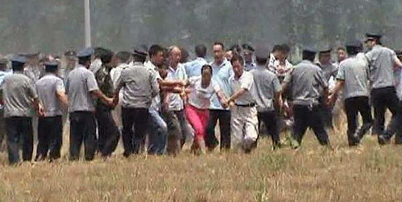 2013年5月28日，五龍口鎮東逯寨村近百村民趕到耕地，眼見挖掘機正破壞農田，立即衝上前阻止，排成人鏈的防暴警察則驅趕村民離場。（村民攝）