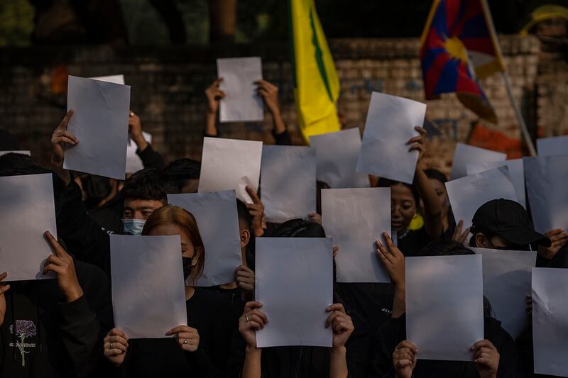 流亡印度的藏族人士12月2日手持白纸、口中呼喊反中口号，聚集在新德里街头抗议中国的监视政策 。(美联社)