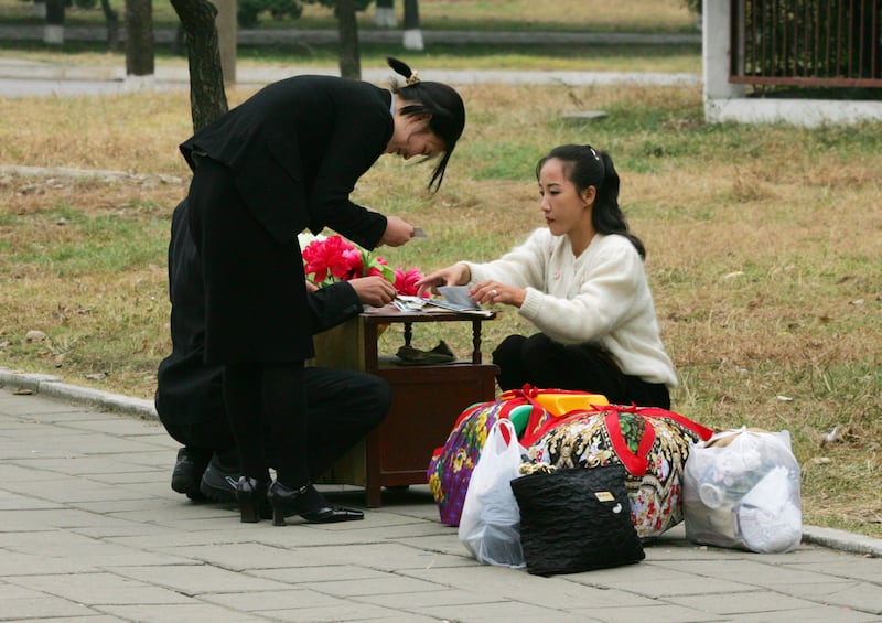 2005년 10월, 평양 시내 거리에서 한 북한 여성이 손수 만든 물품을 판매하고 있다.