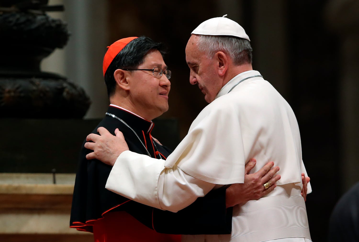 Pope Francis hugs Filipino Cardinal Luis Antonio Tagle (L) before blessing a mosaic of St. Pedro Calungsod's image during a meeting with the Philippine community at the St Peter Basilica in Vatican Nov. 21, 2013.