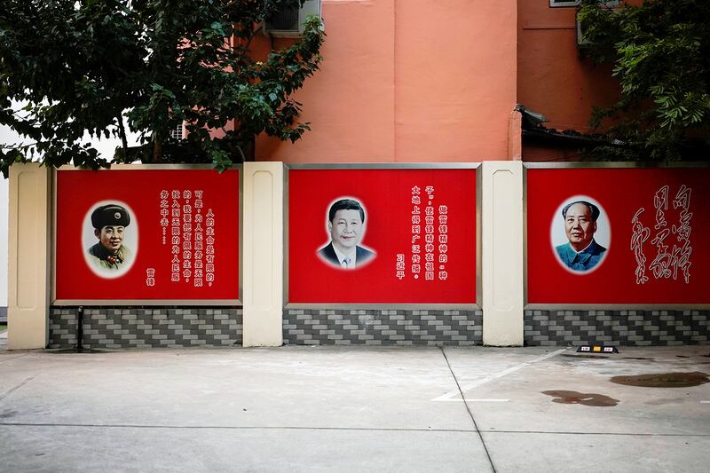 Pictures of late People's Liberation Army soldier Lei Feng, Chinese President Xi Jinping and late Chinese Chairman Mao Zedong overlook a courtyard in Shanghai, China, September 26, 2017.