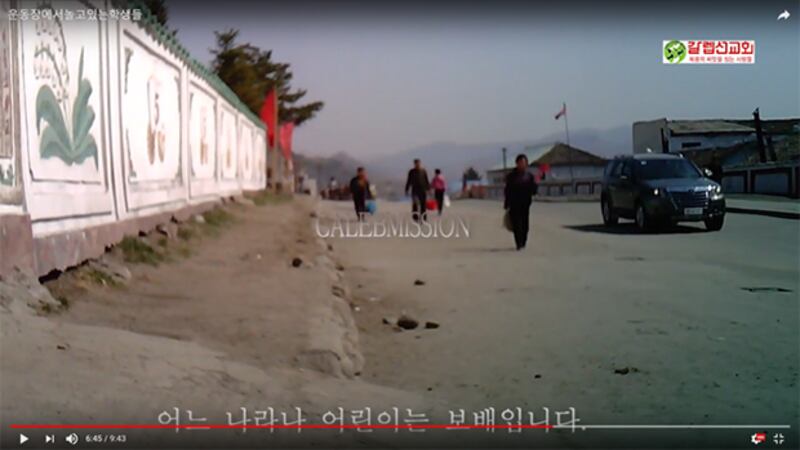 차와 사람이 함께 다니는 학교 운동장 입구 모습.