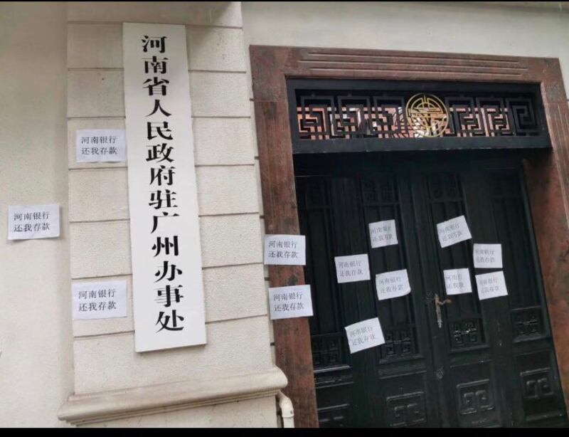 河南銀行苦主在抗議後,把抗議標語貼在河南省人民政府駐廣州辦事處門前。(網絡截圖)