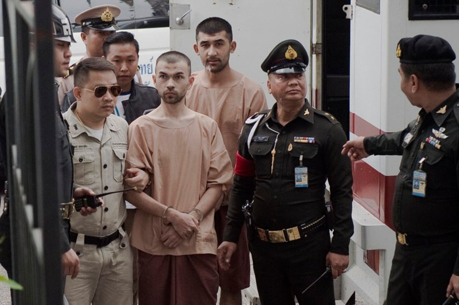 Uyghurs Adem Karadag (center) and Yusufu Mieraili, suspects in the August 2015 Erawan Shrine bombing, are escorted by authorities for a court hearing in Bangkok, Feb. 16, 2016.