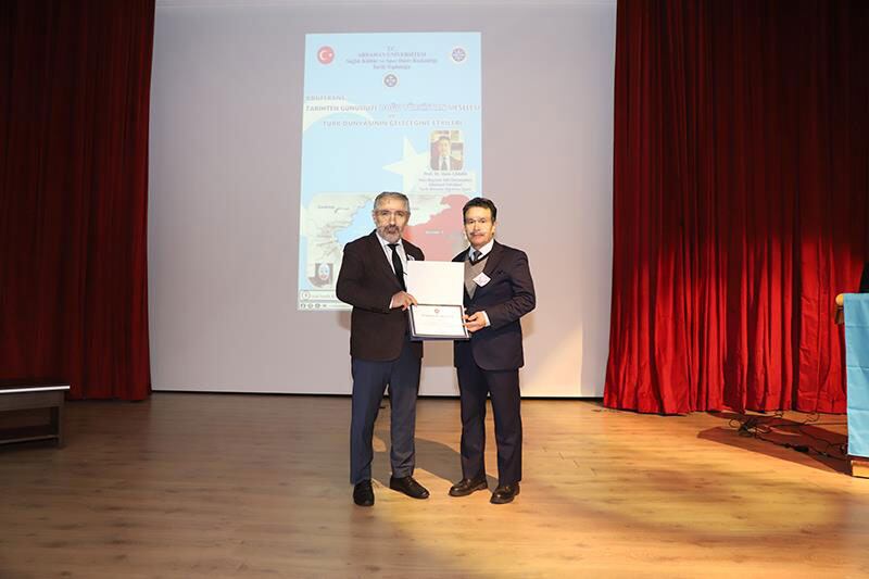 دوكتور سۇئات ۋۇرال ئەپەندى پىروفېسسور در. ۋارىس چاقان ئەپەندىنىڭ سۆزلىرىگە تەشەككۈر ئېيتىپ خاتىرە بويۇم تەقدىم قىلدى. 2024-يىلى 28-نويابىر، تۈركىيە.
