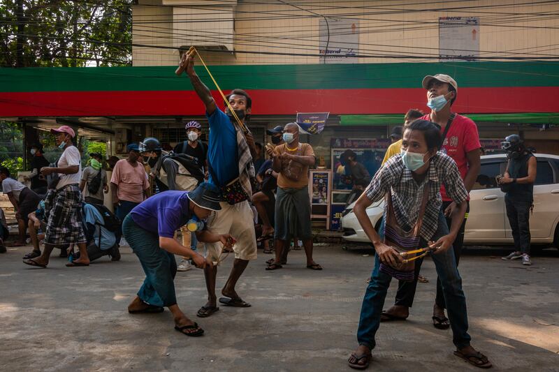 Anti-coup protesters prepare to use slingshots against security forces on March 28, 2021 in Yangon, Myanmar.