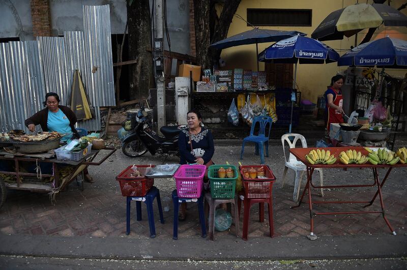 In this Feb. 9, 2015 photo, street food vendors wait for customers in Vientiane. Credit: Christophe Archambault/AFP)