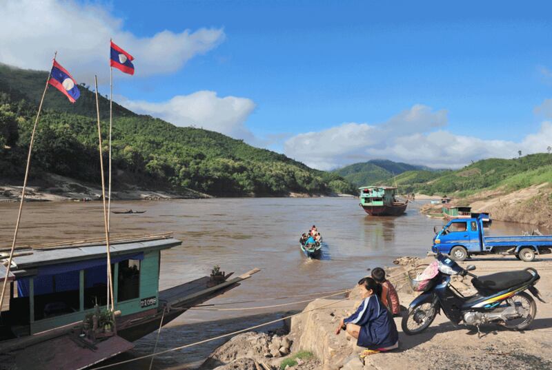 Hình minh họa. Một phụ nữ ngồi nhìn những con thuyền đi qua tại Pak Beng trên dòng Mekong ở Lào