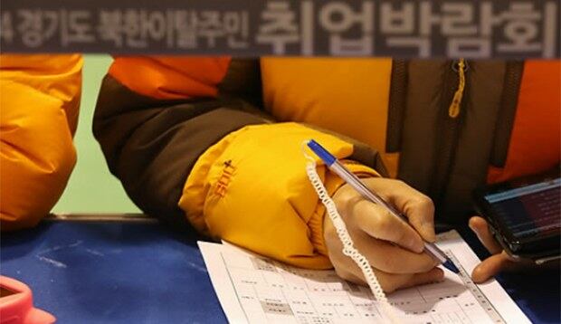 경기도 북한이탈주민 취업박람회에서 한 구직자가 정성스럽게 입사지원서를 작성하고 있다.