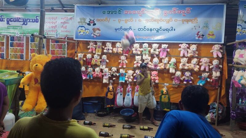 မန္တလေးတိုင်း ညောင်ဦးမြို့ ရွှေစည်းခုံဘုရားအနီးတွင် ရောင်းချနေသည့် ဆယ့်နှစ်ပွဲစျေးသည်များနှင့် ပွဲဈေးလာသူများကို ၂၀၂၃ ခုနှစ် ဇွန်လ ၁ ရက်နေ့ညက တွေ့ရစဉ်။ (Photo: RFA)