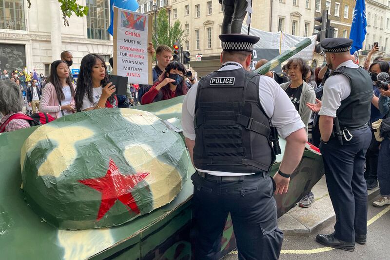 一批香港示威者多次抬起貼上「毋忘六四」字句的自製紙坦克衝向中國大使館，被當地警方攔下。（呂熙 攝）