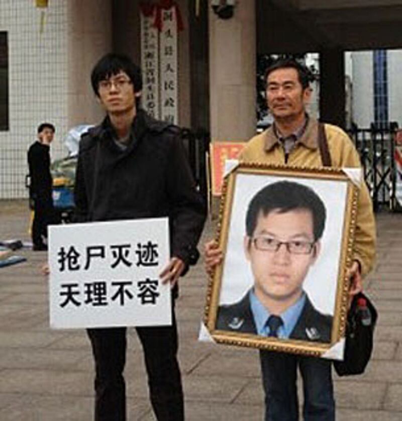 死者父親和哥哥到縣公安局門外,高舉橫額抗議當局搶走屍體以圖毀屍滅跡。(相片由死者家屬提供)