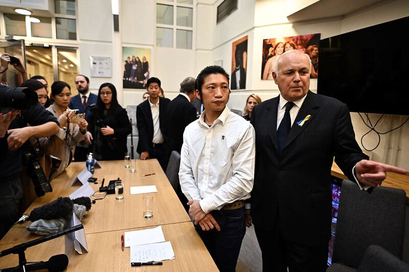 2022年10月19日，在伦敦举行的新闻发布会上，香港民主抗议者鲍勃·陈与英国保守党前领袖伊恩·邓肯·史密斯。（法新社）