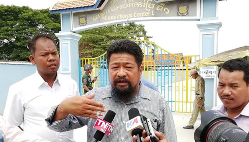 លោក អ៊ូ ច័ន្ទរិទ្ធិ និង តំណាងរាស្ត្របក្សប្រឆាំង ផ្ដល់បទសម្ភាសន៍ឲ្យអ្នកសារព័ត៌មាននៅមុខមណ្ឌលកែប្រែម១ ឬពន្ធនាគារព្រៃ នៅព្រឹកថ្ងៃទី២៦ កក្កដា បន្ទាប់ពីបានចូលទៅជួប សកម្មជន និង តំណាងរាស្ត្របក្សប្រឆាំង១៥រូប កំពុងជាប់ឃុំ។ រូបថត ហ្វេសប៊ុករបស់ លោក អ៊ូ ច័ន្ទរិទ្ធិ។