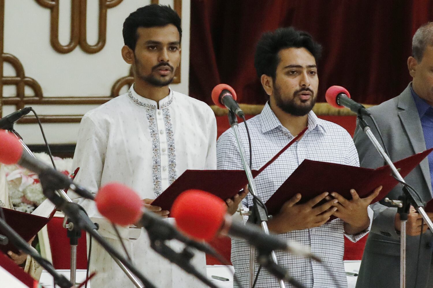 Asif Mahmud, left, and Nahid Islam, university students and key figures in the anti-quota protests that turned into a nationwide movement against the Sheikh Hasina government, are sworn in as members of the interim Bangladesh government at the Presidential House in Dhaka, Aug. 8, 2024. (Rajib Dhar/AP)