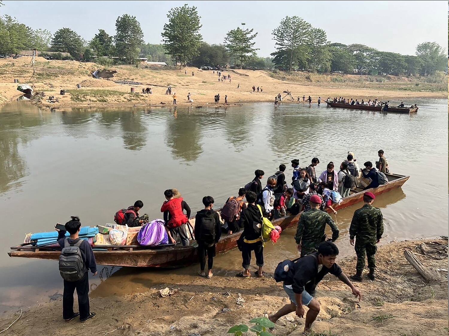 People from Myanmar cross the Moei river on the Thai-Myanmar border on April 11, 2023.