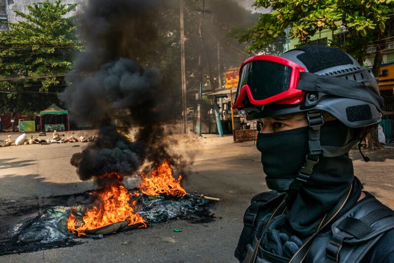 Protesters set fire to tires on a road to slow the progress of security forces on March 27, 2021 in Yangon, Myanmar.