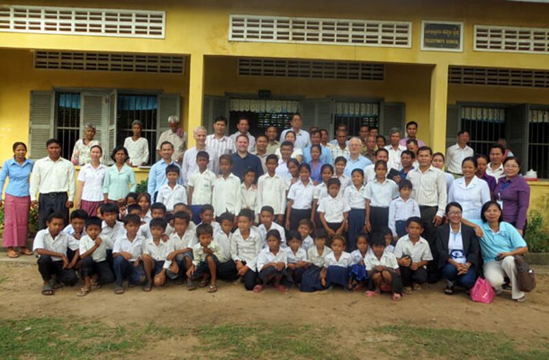 មន្ត្រីស្ថានទូតសហរដ្ឋអាមេរិក មន្ត្រីអង្គការស្បៀងអាហារពិភពលោកប្រចាំប្រទេសកម្ពុជា រួមនឹងមន្ត្រីក្រសួងអប់រំ ថតរូបអនុស្សាវរីយ៍ពេលចុះពិនិត្យលើការផ្ដល់របបអាហារពេលព្រឹកដល់កុមារនៅសាលាបឋមសិក្សាមួយ ក្នុងខេត្តកំពង់ធំ នៅថ្ងៃ១០ មិថុនា ២០១៤។