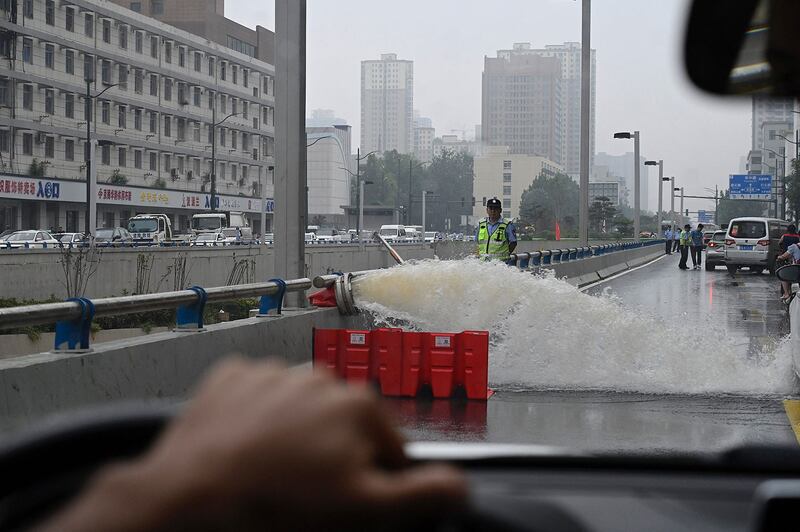 2021年7 月 23 日，河南省郑州市，救援人员使用抽水机从隧道的积水进行抽排 。（法新社）
