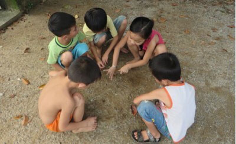 Trẻ quê chơi bắn bi ngày hè. RFA photo