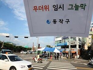 폭염이 이어진 14일 오후 서울 동작구 노량진역 부근 횡단보도에 구청이 설치한 임시 그늘막에서 시민들이 신호를 기다리며 더위를 피하고 있다. 