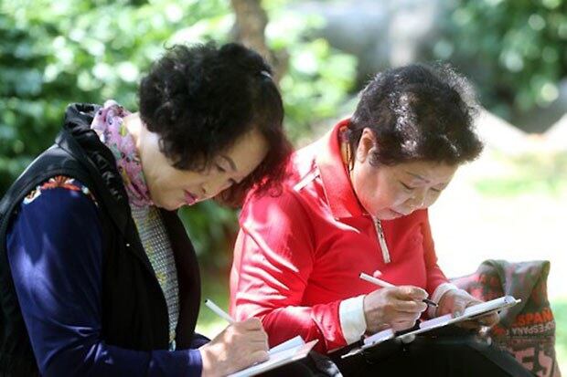 서울 영등포구 영등포공원에서 열린 '제10회 영등포 여성백일장'에서 참가자들이 나무그늘 아래 앉아 글짓기를 하고 있다.