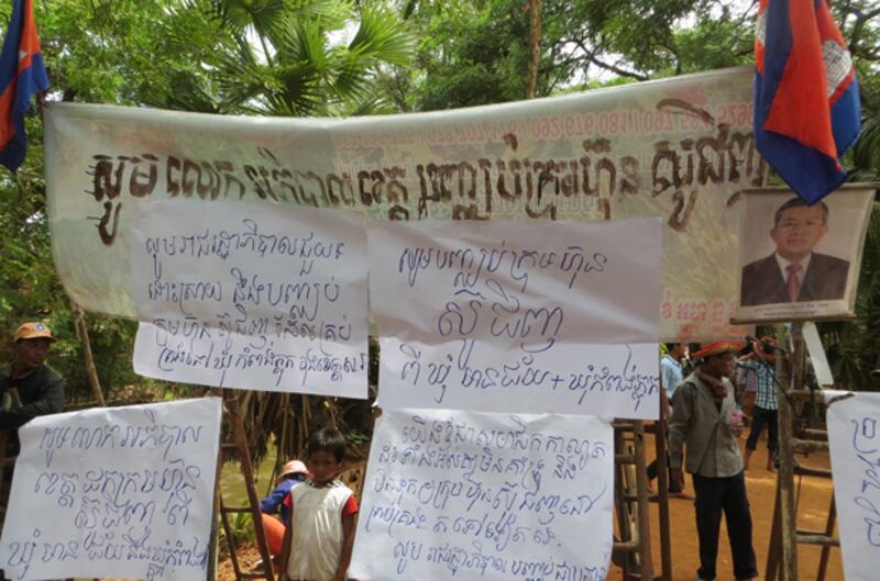 ផ្ទាំង​បដា​ដែល​ប្រជាពលរដ្ឋ​ឃុំ​កំពង់ភ្លុក និង​ឃុំ​មានជ័យ ដាក់​ចង​ព្យួរ​នៅ​ពេល​បិទ​ផ្លូវ​តវ៉ា​ប្រឆាំង​ក្រុមហ៊ុន ស៊ូ ជីង (Suo Jing) នា​ខេត្ត​សៀមរាប កាល​ពី​ថ្ងៃ​ទី​២៥ ខែ​កញ្ញា ឆ្នាំ​២០១៤។ 