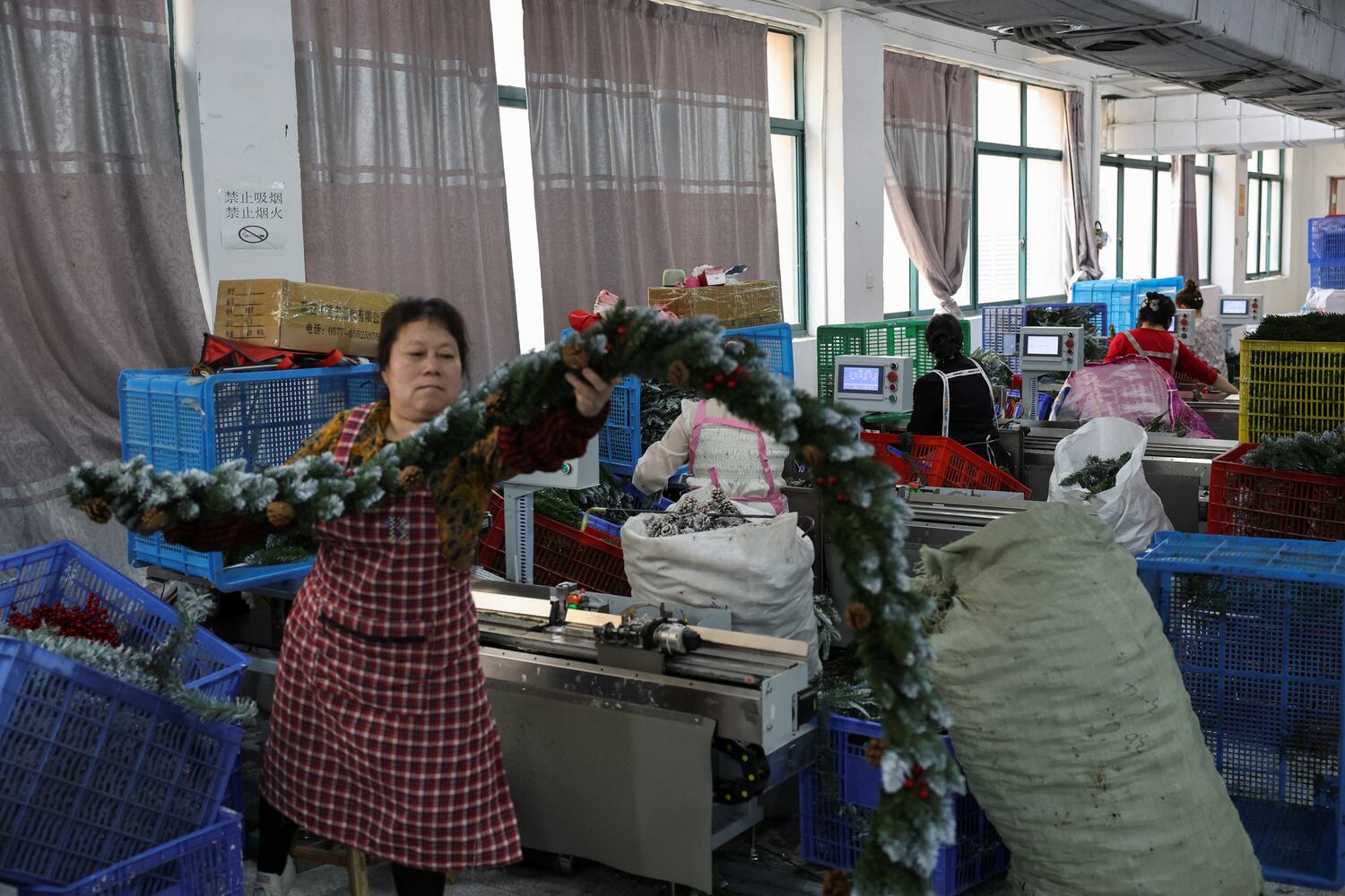 Employees at an artificial Christmas tree at factory in Shaoxing, Zhejiang province, China, April 9, 2025.