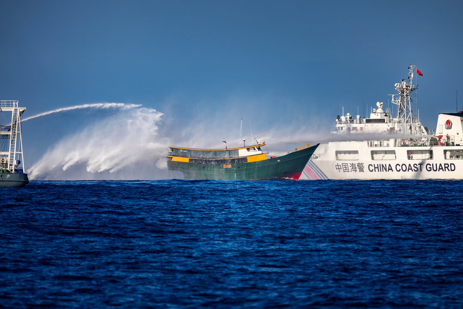 A Chinese Coast Guard ship fires a water cannon at Unaizah May 4, a Philippine Navy chartered vessel, conducting a routine resupply mission to troops stationed at Second Thomas Shoal, on March 5, 2024 in the South China Sea.