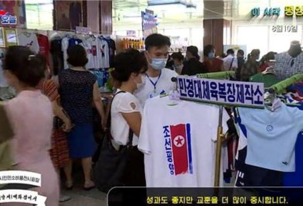 평양제1백화점 평양시인민소비품전시회장의 의류 매장. 북한 국기가 새겨진 티셔츠가 전면에 걸려 있다.