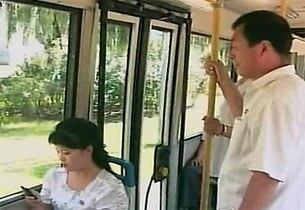 버스 안에서 휴대전화를 사용하는 북한 여성.